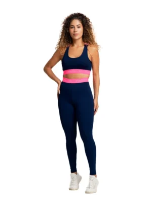 Mulher vestindo conjunto fitness Massam, composto por legging marinho e top com detalhe neon pink, ideal para treinos na academia.