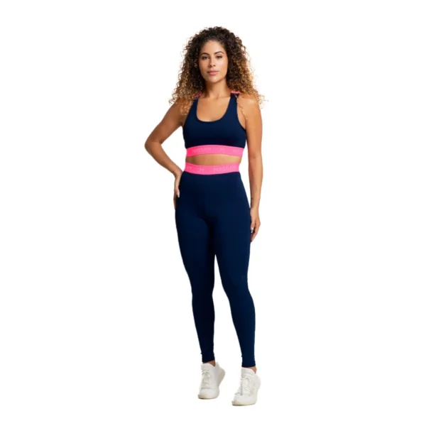 Mulher vestindo conjunto fitness Massam, composto por legging marinho e top com detalhe neon pink, ideal para treinos na academia.