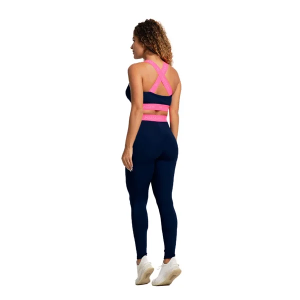 Vista traseira do conjunto fitness Massam, destacando as alças cruzadas do top neon pink e a legging marinho, perfeita para exercícios físicos.