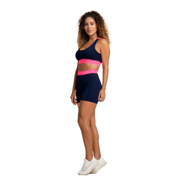 Vista lateral de conjunto fitness feminino com detalhes neon pink e tecnologia de compressão e UV50+.